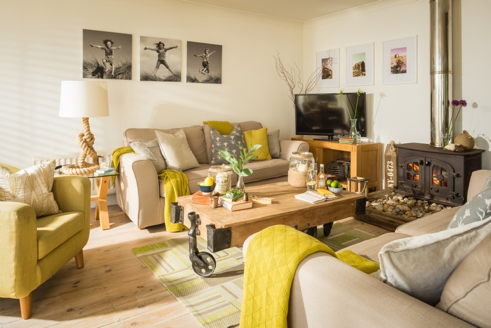 Mittelgroßes Maritimes Wohnzimmer mit weißer Wandfarbe, hellem Holzboden, Kaminofen, freistehendem TV, beigem Boden und Kaminumrandung aus Metall in Sussex
