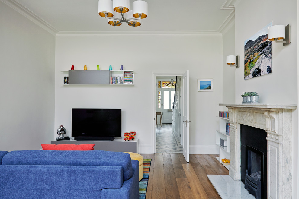 Mittelgroßes, Offenes Modernes Wohnzimmer mit weißer Wandfarbe, braunem Holzboden, Kamin und Kaminumrandung aus Stein in London