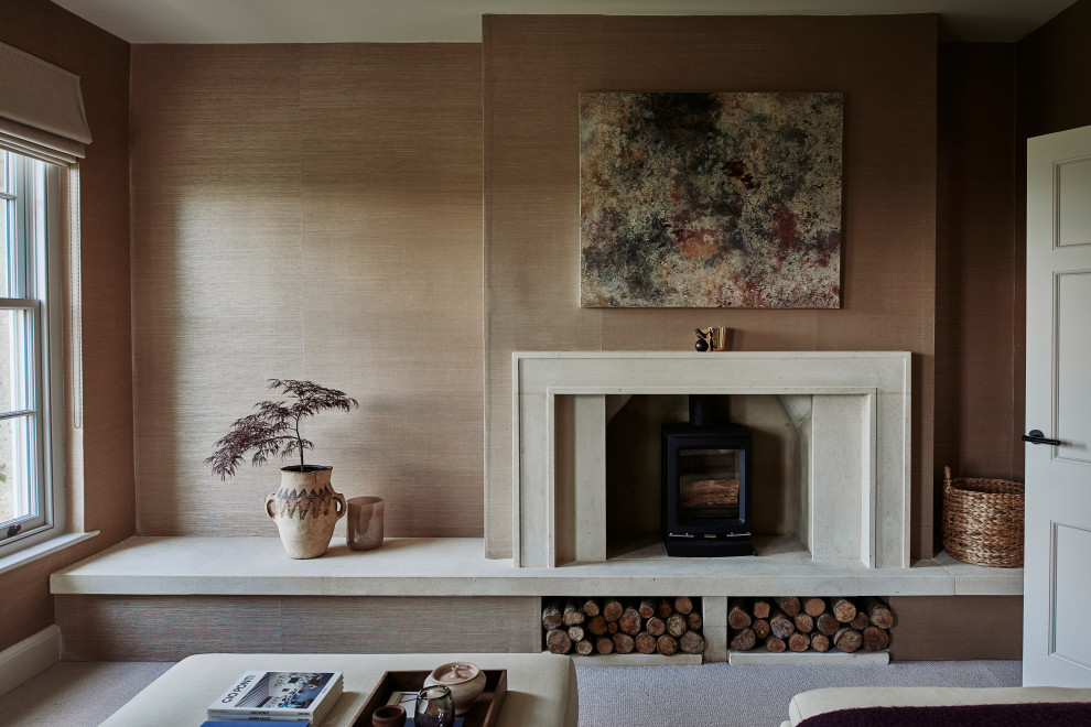Diseño de sala de estar cerrada tradicional renovada de tamaño medio con paredes rosas, moqueta, estufa de leña, marco de chimenea de piedra y televisor independiente