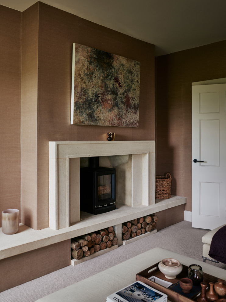 На фото: изолированная гостиная комната среднего размера в стиле неоклассика (современная классика) с розовыми стенами, ковровым покрытием, печью-буржуйкой, фасадом камина из камня и отдельно стоящим телевизором