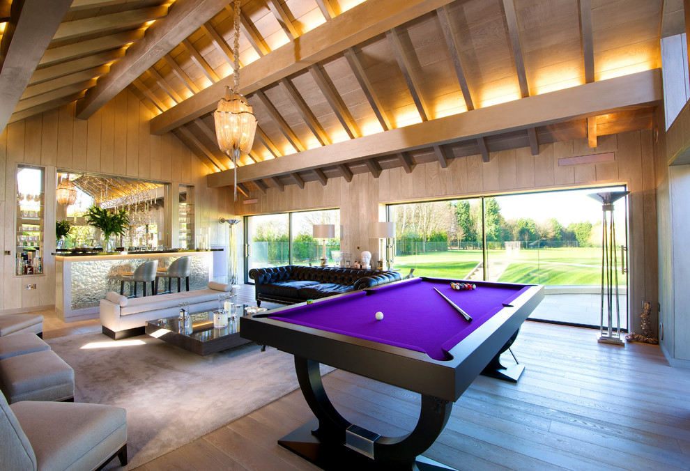 This is an example of a contemporary open plan games room in Cheshire with medium hardwood flooring and no tv.