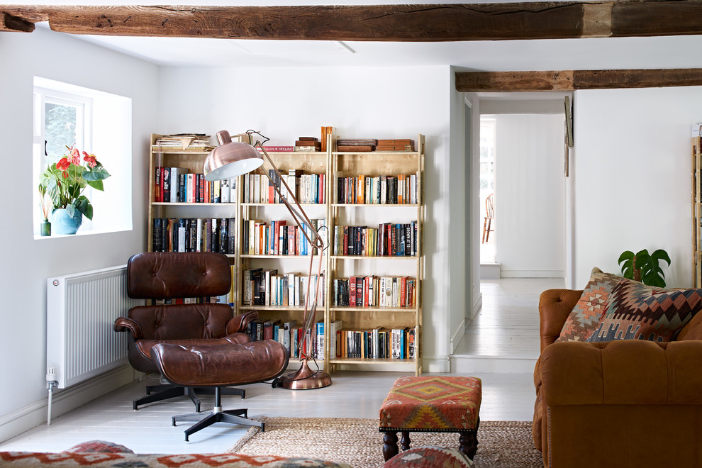 Imagen de sala de estar con biblioteca de estilo de casa de campo sin televisor con paredes blancas, suelo de madera pintada y suelo blanco