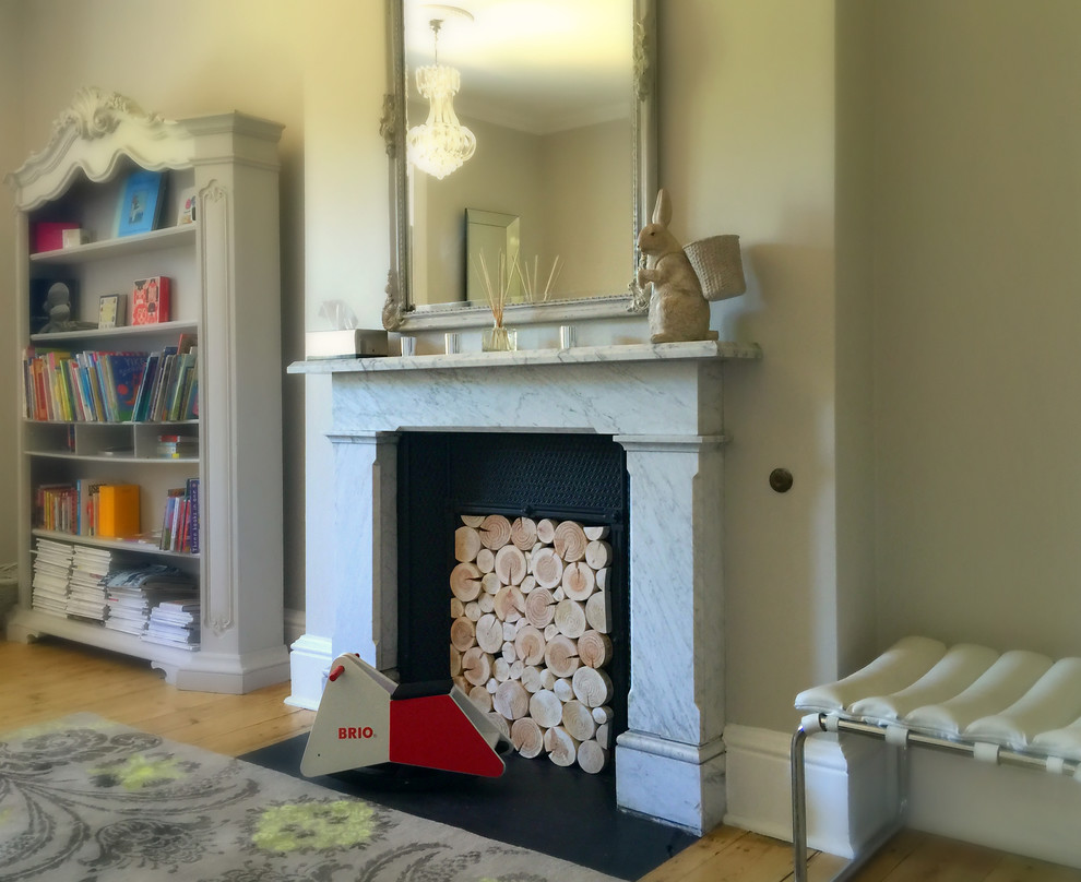 Inspiration for a timeless medium tone wood floor family room remodel in Gloucestershire with a standard fireplace