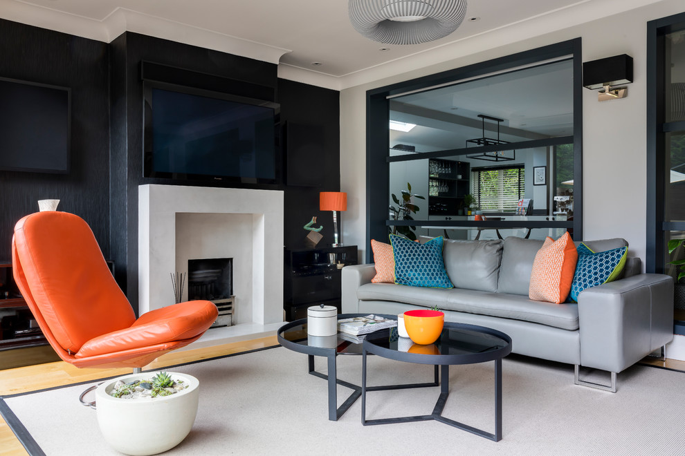 Mittelgroßes Modernes Wohnzimmer mit verputzter Kaminumrandung, grauer Wandfarbe, hellem Holzboden, Kamin und TV-Wand in London