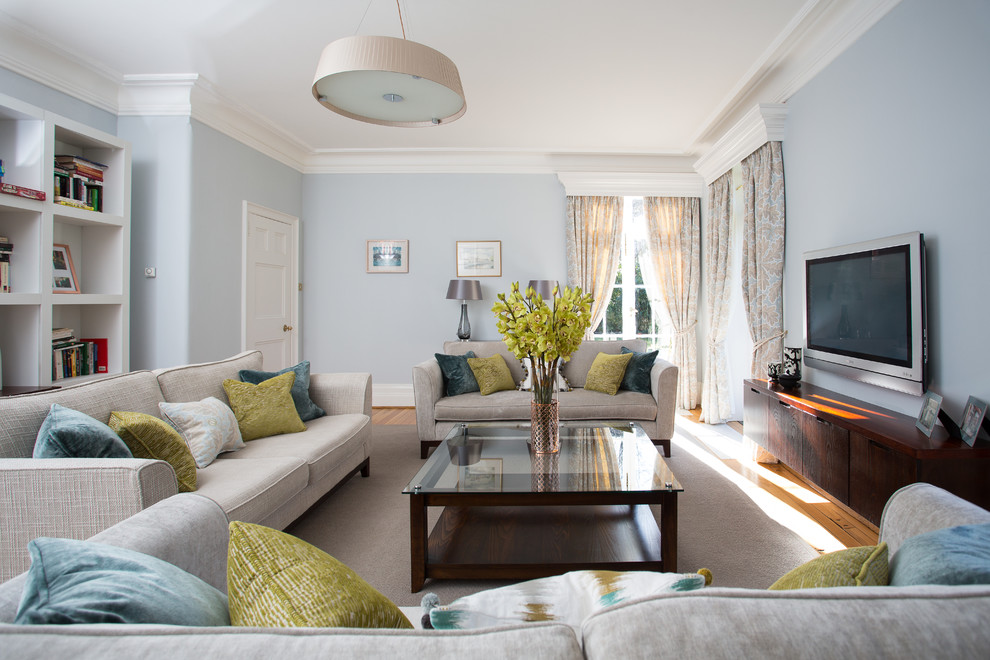 Großes, Abgetrenntes Klassisches Wohnzimmer ohne Kamin mit blauer Wandfarbe, braunem Holzboden und TV-Wand in Dublin