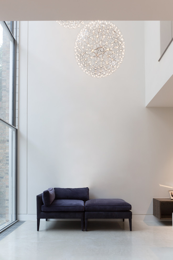 Свежая идея для дизайна: двухуровневая гостиная комната в стиле модернизм с белыми стенами, бетонным полом и телевизором на стене без камина - отличное фото интерьера