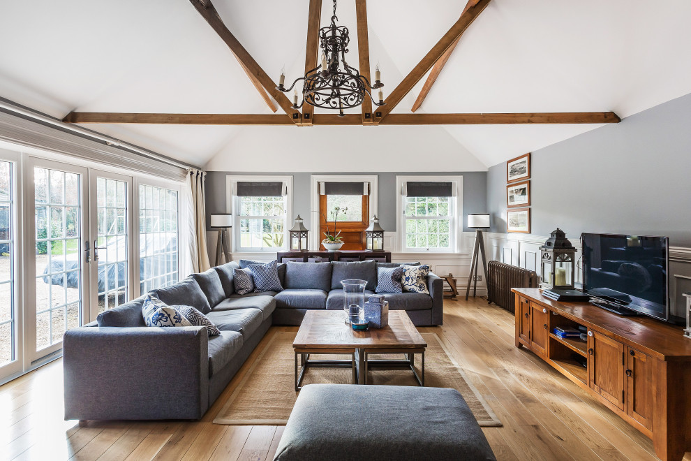 Foto di un grande soggiorno tradizionale aperto con pareti grigie, parquet chiaro, soffitto a volta e pannellatura