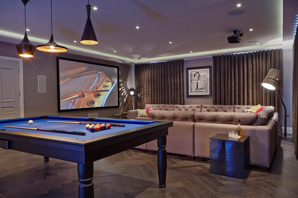 Foto de sala de juegos en casa actual con paredes grises, suelo de madera oscura y televisor colgado en la pared