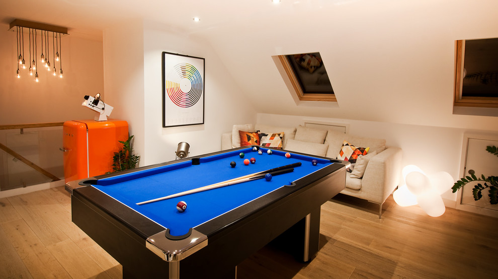 Game room - contemporary open concept light wood floor game room idea in London with a media wall
