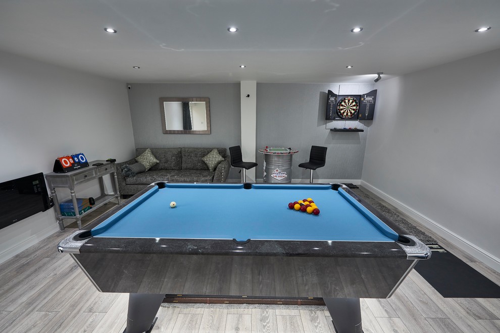 Inspiration for a small modern enclosed games room in Other with a game room, grey walls, laminate floors, a wall mounted tv and grey floors.