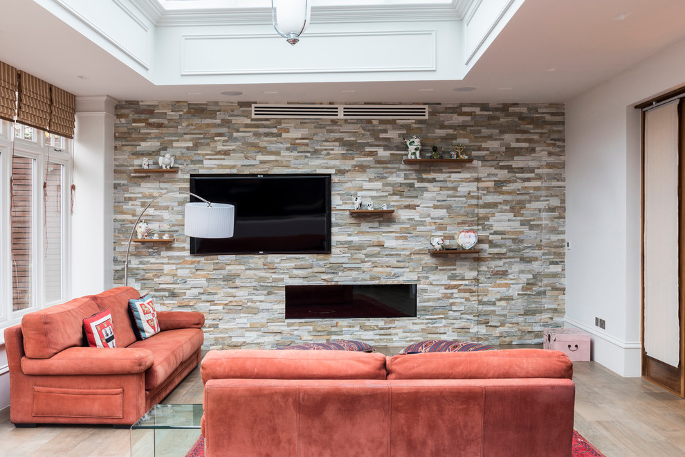 Diseño de sala de estar con biblioteca abierta contemporánea de tamaño medio con paredes beige, suelo de baldosas de porcelana, chimenea lineal, marco de chimenea de piedra y pared multimedia