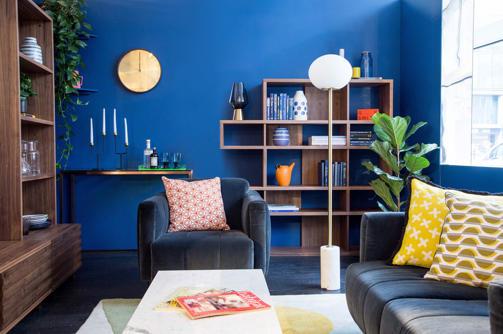 Mid-sized trendy enclosed dark wood floor and black floor family room photo in London with blue walls