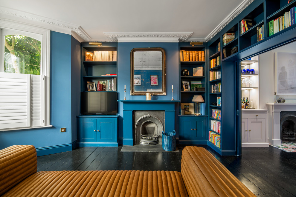 Идея дизайна: изолированная гостиная комната в стиле неоклассика (современная классика) с синими стенами, стандартным камином, с книжными шкафами и полками, темным паркетным полом и мультимедийным центром