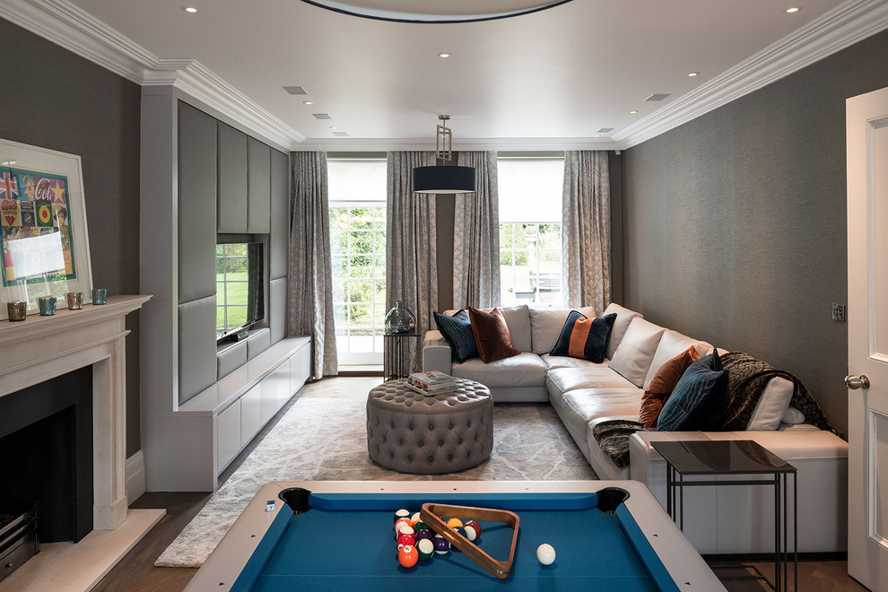 Diseño de sala de estar contemporánea con paredes grises, suelo de madera oscura, pared multimedia, todas las chimeneas y alfombra
