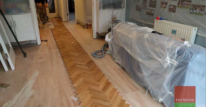 Large midcentury games room in London with light hardwood flooring.