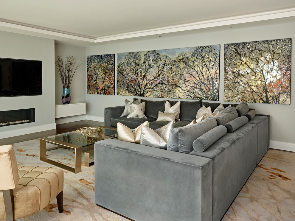 Идея дизайна: гостиная комната в современном стиле с серыми стенами, темным паркетным полом, горизонтальным камином и телевизором на стене