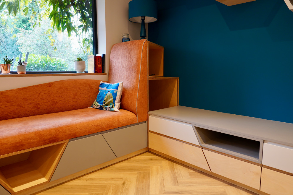 Ispirazione per un soggiorno scandinavo di medie dimensioni e aperto con libreria, pareti blu, pavimento in legno massello medio e pavimento marrone
