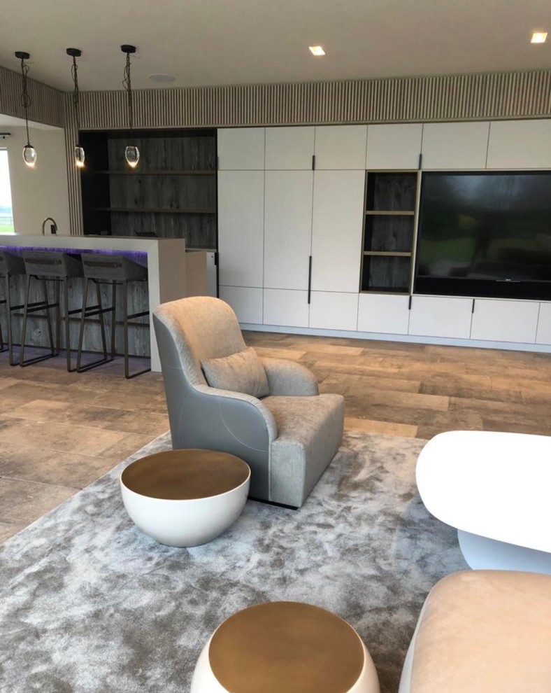 Diseño de sala de estar con barra de bar abierta contemporánea grande con paredes blancas, suelo de baldosas de cerámica, televisor colgado en la pared y suelo gris