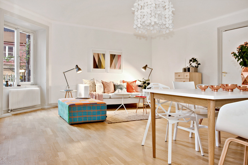 Offenes Nordisches Wohnzimmer mit weißer Wandfarbe und hellem Holzboden in Stockholm