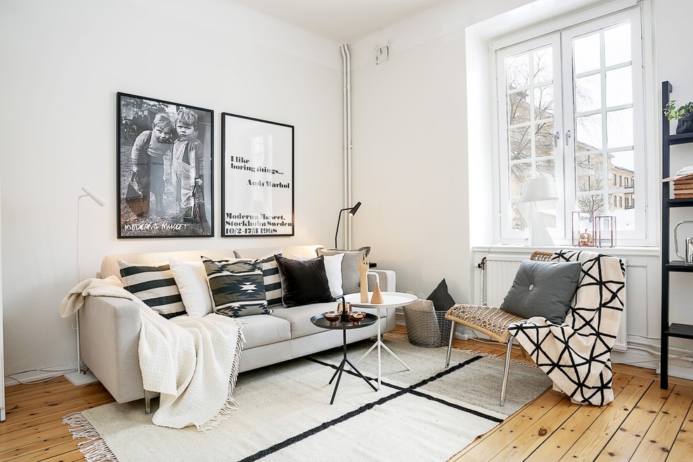 Inspiration for a mid-sized scandinavian open concept medium tone wood floor family room remodel in Stockholm with white walls, no fireplace and no tv