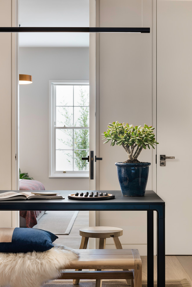Diseño de sala de estar contemporánea con paredes blancas, suelo de madera clara y suelo beige