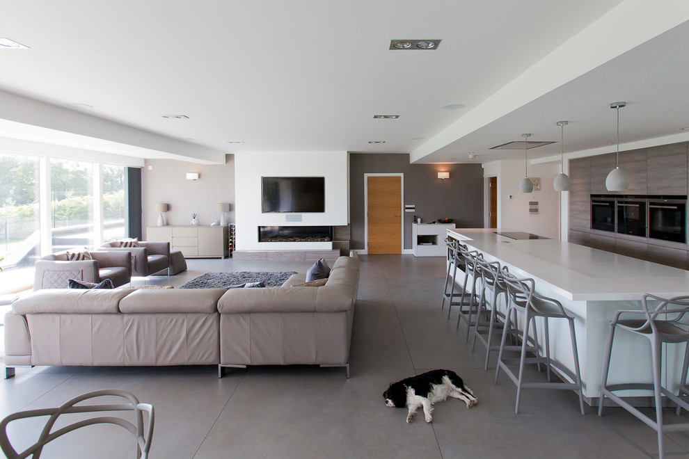 На фото: открытая гостиная комната в современном стиле с горизонтальным камином и телевизором на стене с