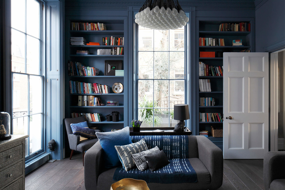 Immagine di un soggiorno eclettico chiuso con libreria, pareti blu, parquet scuro e pavimento grigio