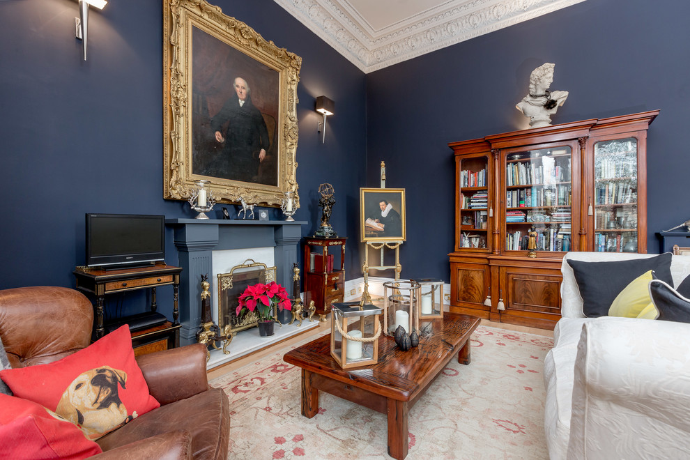 Источник вдохновения для домашнего уюта: открытая гостиная комната в стиле фьюжн с с книжными шкафами и полками, синими стенами, стандартным камином и отдельно стоящим телевизором