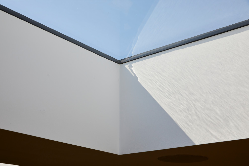 Пример оригинального дизайна: открытая гостиная комната среднего размера в стиле модернизм с белыми стенами, ковровым покрытием, серым полом и сводчатым потолком
