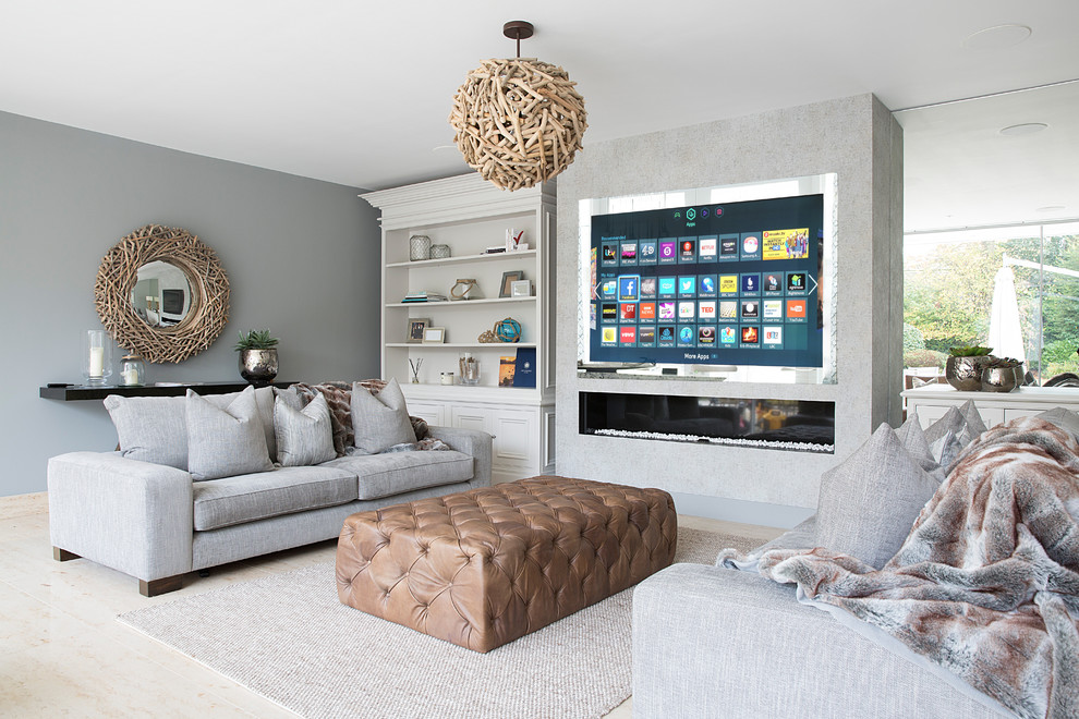 Mid-sized beach style enclosed family room photo in Cheshire with gray walls, a ribbon fireplace and a media wall