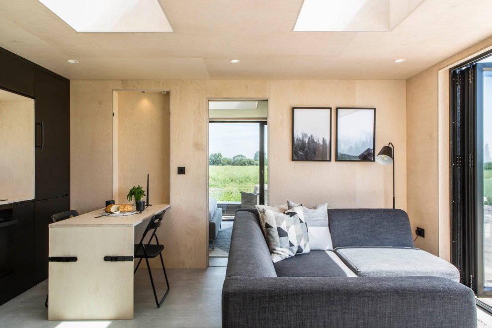 Modelo de sala de estar abierta nórdica pequeña sin chimenea con paredes beige, suelo de cemento y suelo gris