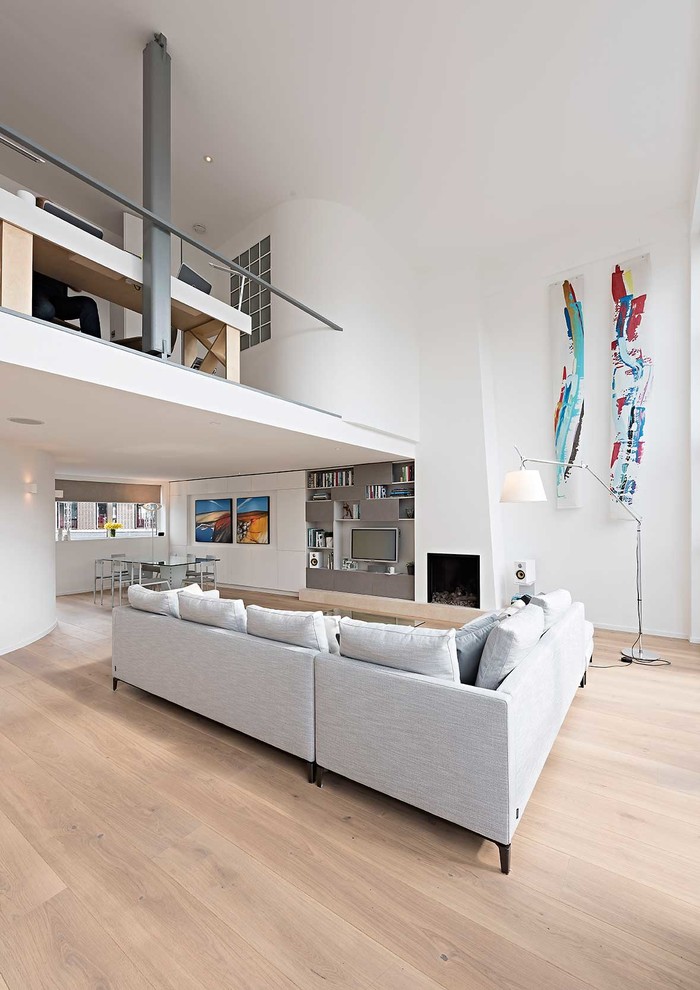 Foto di un soggiorno minimal di medie dimensioni e aperto con pareti bianche, parquet chiaro, camino classico e TV a parete