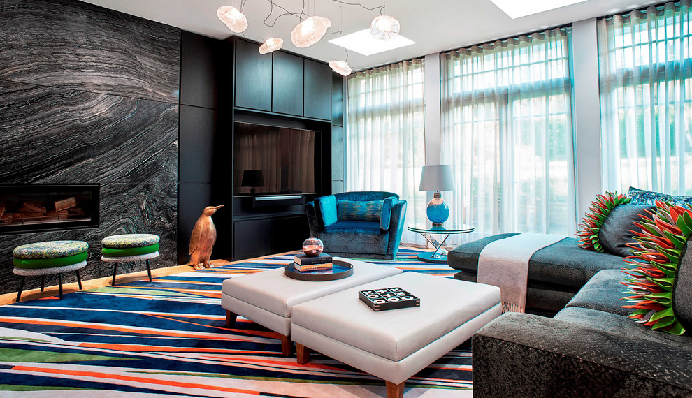 Offenes Modernes Wohnzimmer mit schwarzer Wandfarbe, Gaskamin, Kaminumrandung aus Stein und Multimediawand in London