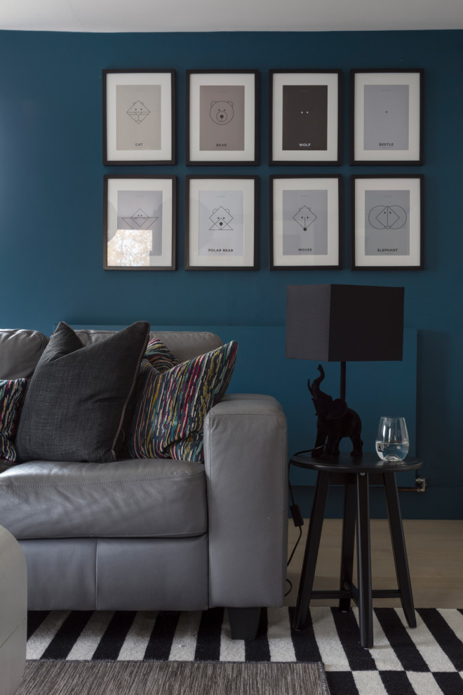 Großes, Abgetrenntes Landhaus Wohnzimmer mit blauer Wandfarbe, hellem Holzboden und Multimediawand in Sonstige