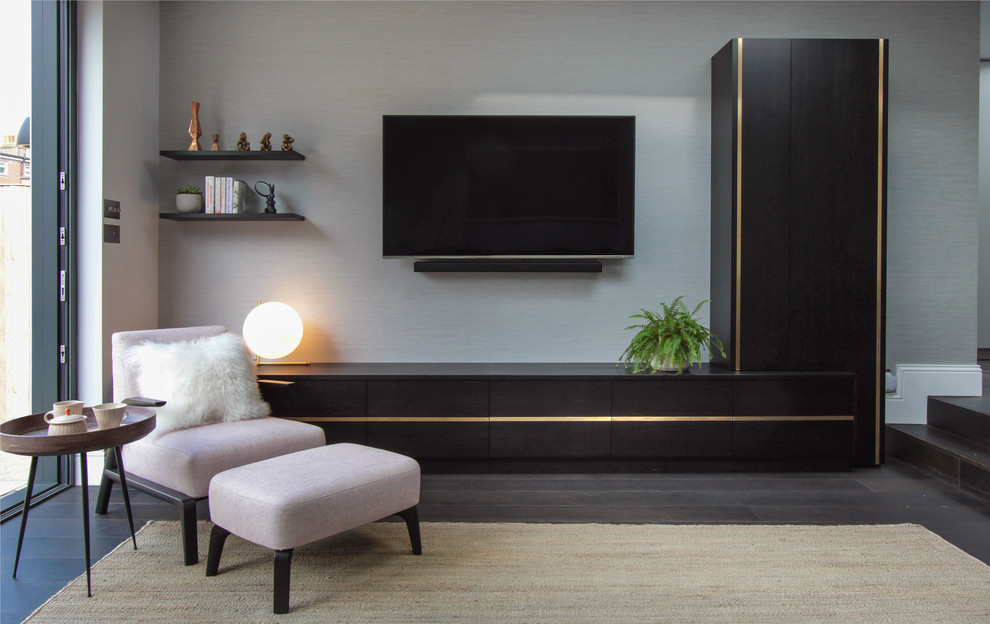 Immagine di un grande soggiorno minimalista aperto con libreria, pareti blu, parquet scuro, nessun camino, TV a parete e pavimento marrone