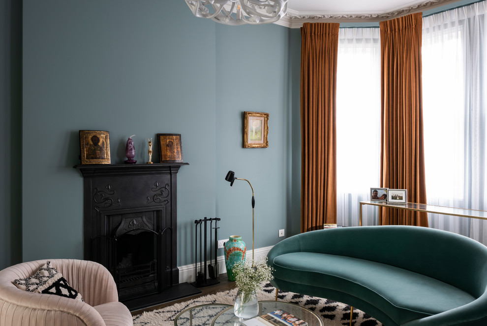 Ejemplo de sala de estar tradicional renovada con paredes azules, suelo de madera oscura y todas las chimeneas