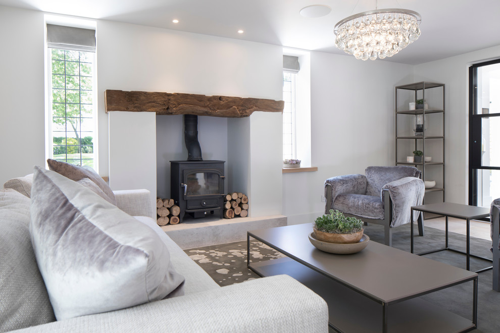 Photo of a medium sized contemporary open plan games room in Cheshire with a reading nook, white walls, ceramic flooring, a wood burning stove, a plastered fireplace surround, no tv and white floors.