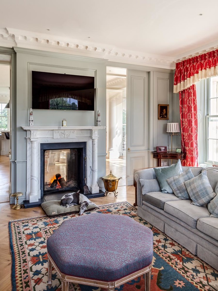 Inspiration for a classic games room in Gloucestershire with medium hardwood flooring, a two-sided fireplace and a stone fireplace surround.