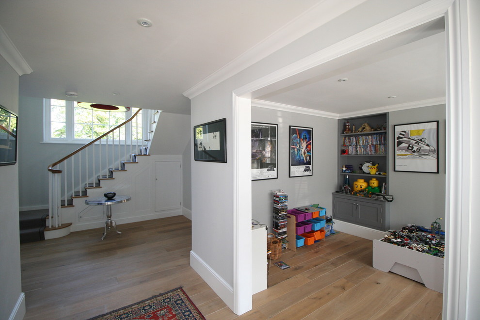 Ejemplo de sala de juegos en casa abierta clásica pequeña sin chimenea y televisor con paredes grises y suelo de madera clara