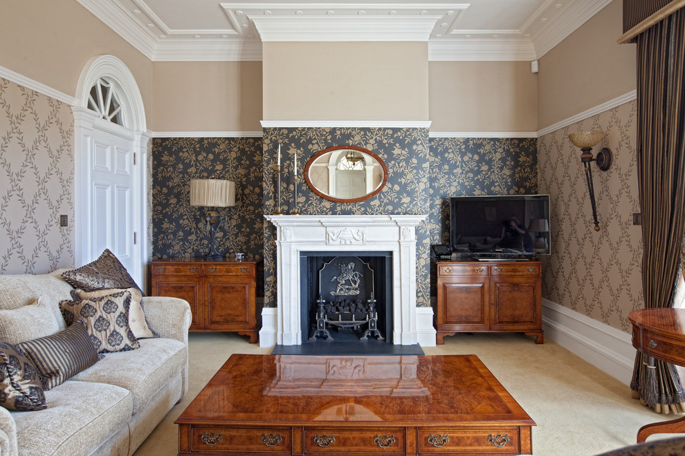 ケンブリッジシャーにある高級な中くらいなトラディショナルスタイルのおしゃれな独立型ファミリールーム (ベージュの壁、カーペット敷き、標準型暖炉、石材の暖炉まわり、据え置き型テレビ、ベージュの床) の写真