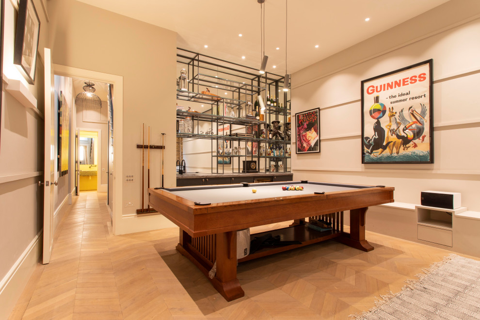 This is an example of a contemporary games room in London with beige walls, medium hardwood flooring and brown floors.