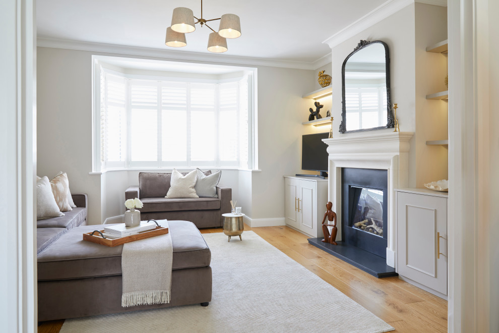 Design ideas for a classic enclosed games room in London with grey walls, medium hardwood flooring, a standard fireplace, brown floors and a chimney breast.