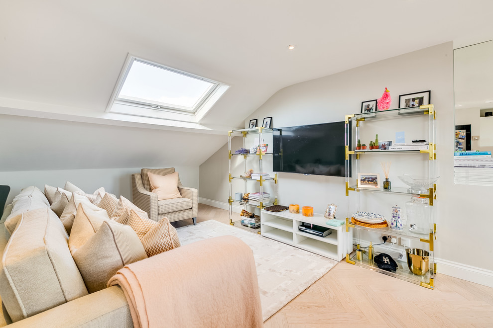 Example of a small transitional open concept light wood floor and beige floor family room design in London with gray walls and a wall-mounted tv