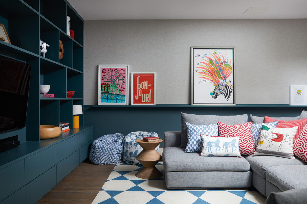 Immagine di un soggiorno contemporaneo chiuso con pareti grigie, pavimento in legno massello medio, nessun camino, parete attrezzata e pavimento marrone