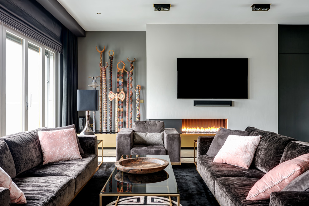 На фото: изолированная гостиная комната среднего размера в современном стиле с ковровым покрытием, горизонтальным камином, фасадом камина из штукатурки, телевизором на стене и черным полом