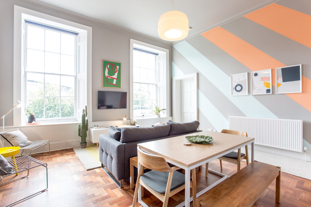 Aménagement d'une salle de séjour contemporaine de taille moyenne et ouverte avec un mur multicolore, un téléviseur fixé au mur, un sol marron, un sol en bois brun et aucune cheminée.