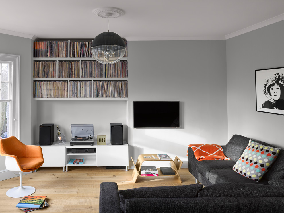 Design ideas for a medium sized contemporary games room in London with grey walls, no fireplace, a wall mounted tv, beige floors and light hardwood flooring.