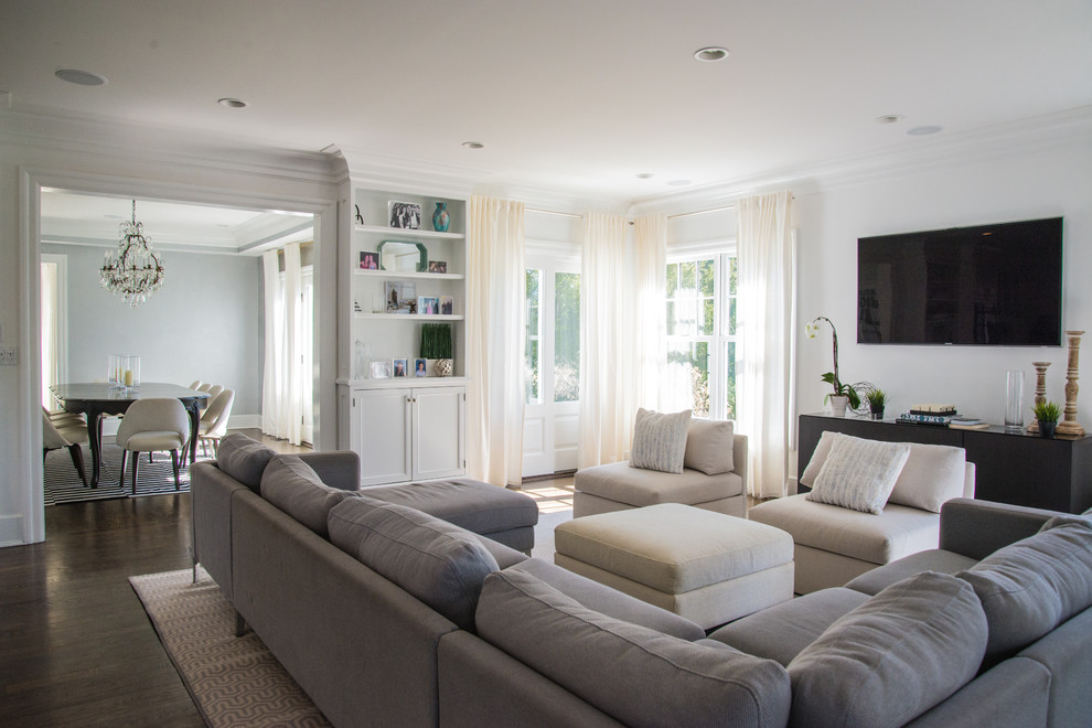 Diseño de sala de estar abierta minimalista de tamaño medio con paredes blancas, suelo de madera oscura, televisor colgado en la pared y alfombra