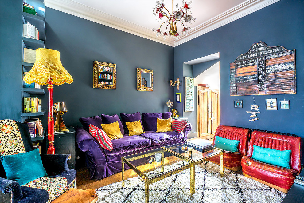 Example of an eclectic enclosed medium tone wood floor and brown floor family room design in London with blue walls