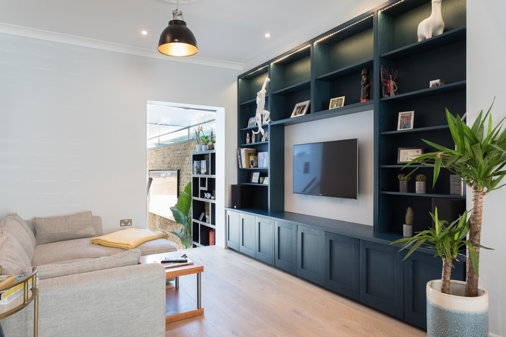 Klassisches Wohnzimmer mit weißer Wandfarbe, hellem Holzboden, TV-Wand und beigem Boden in Sonstige